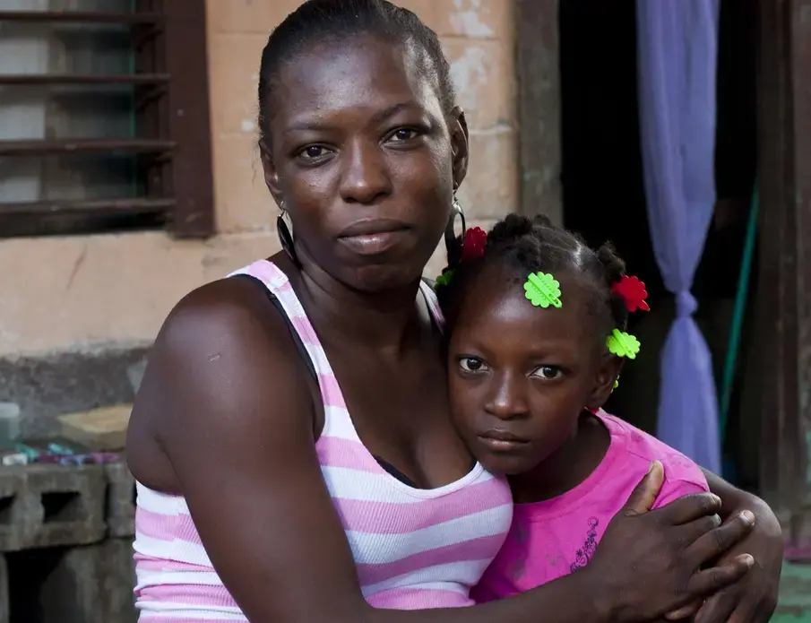 Lesbia Martinez, 33, with her daughter Asly Carolina Cordaba, 8. Lesbia was ostracized by her family when she told them about her HIV diagnosis and once tried to kill herself. Now she says that she wants to be an example in her community and "keep her head high and continue moving forward." Image by David Rochkind. Honduras, 2013. Media file: Lesbia.jpg