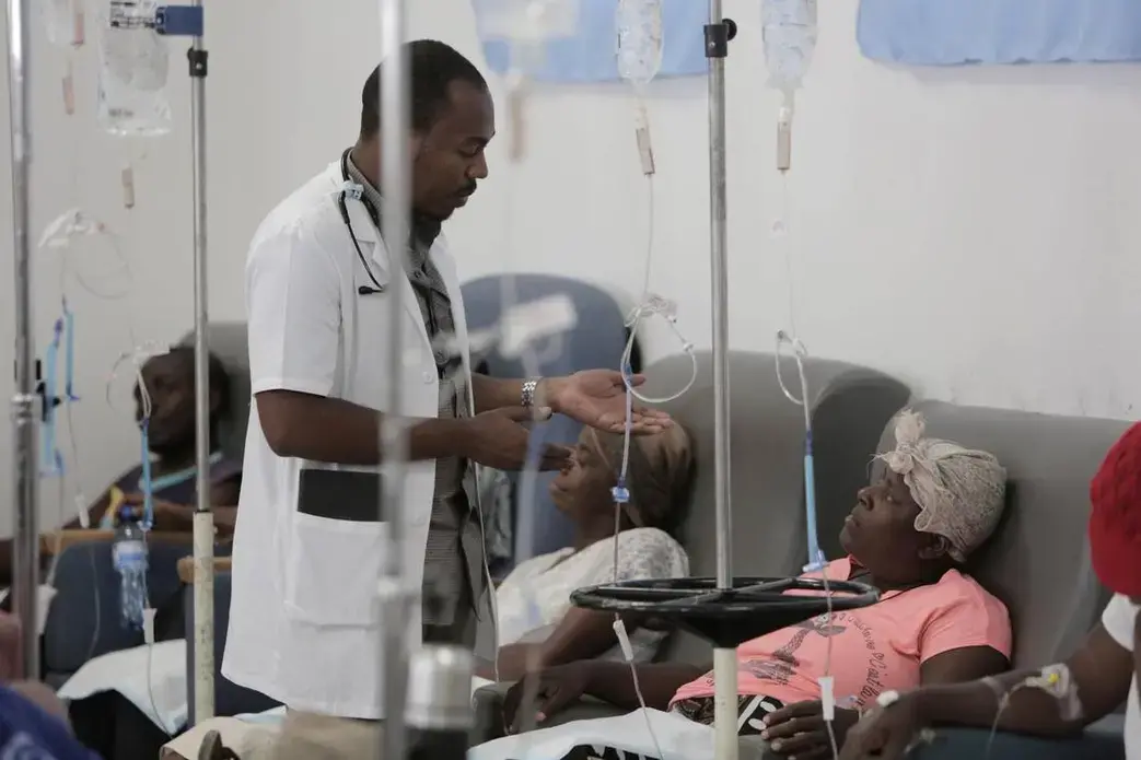 A physician talks to Paula Paul as she gets hydration before chemotherapy at the University Hospital of Mirebalais in central Haiti. Image by José A. Iglesias. Haiti, 2018. A physician talks to Paula Paul as she gets hydration before chemotherapy at the University Hospital of Mirebalais in central Haiti. Image by José A. Iglesias. Haiti, 2018.