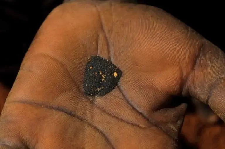 Woman holding gold deposits. Image by Ben Depp. Haiti, 2012.