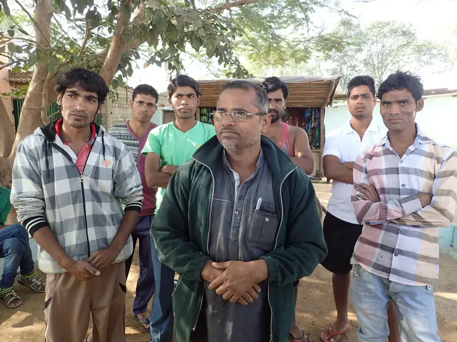 A group of high school and college students standing with a street vendor on the road outside Bade Seepat. Despite their education, they all said they expected to end up migrating to brick kilns like their parents. Image by Yardain Amron. India, 2017. A group of high school and college students standing with a street vendor on the road outside Bade Seepat. Despite their education, they all said they expected to end up migrating to brick kilns like their parents. Image by Yardain Amron. India, 2017.