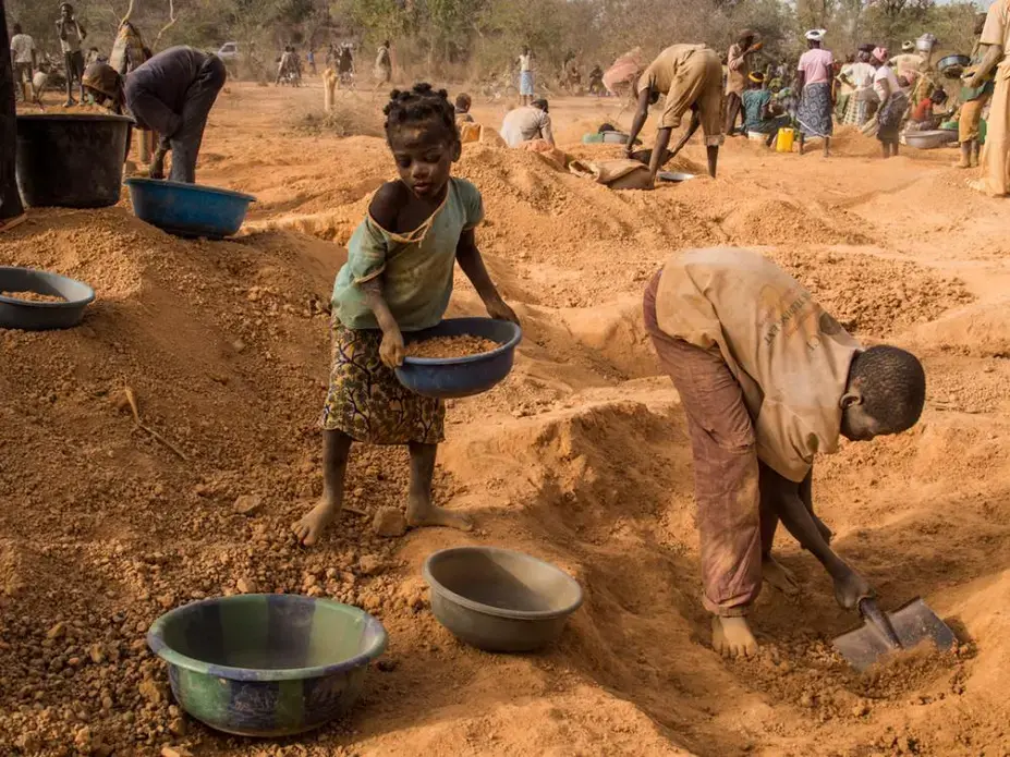 Four-year-old Rasmata Ouedraogo, left, and another child sort pans of soil for sifting. Image by Larry C. Price. Burkina Faso, 2013. Media file: MineIsBorn_Untold_Stories_Price_Burkina_Faso02.jpg