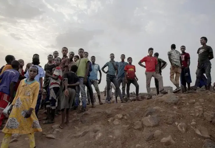 Ethiopian migrants stand on a hill at a slum in Dikhil, Djibouti, where they took shelter after entering the country, July 12, 2019, on their journey to Yemen. Most hope to eventually reach Saudi Arabia. Image by AP Photo / Nariman El-Mofty. Djibouti, 2019.