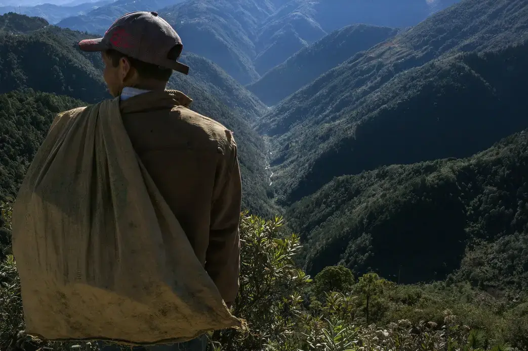 A man pauses above the Captzin River, in the highlands of western Guatemala, on his way home from collecting recyclable materials. Image by Mauricio Lima. Guatemala, 2019. A man pauses above the Captzin River, in the highlands of western Guatemala, on his way home from collecting recyclable materials. Image by Mauricio Lima. Guatemala, 2019.