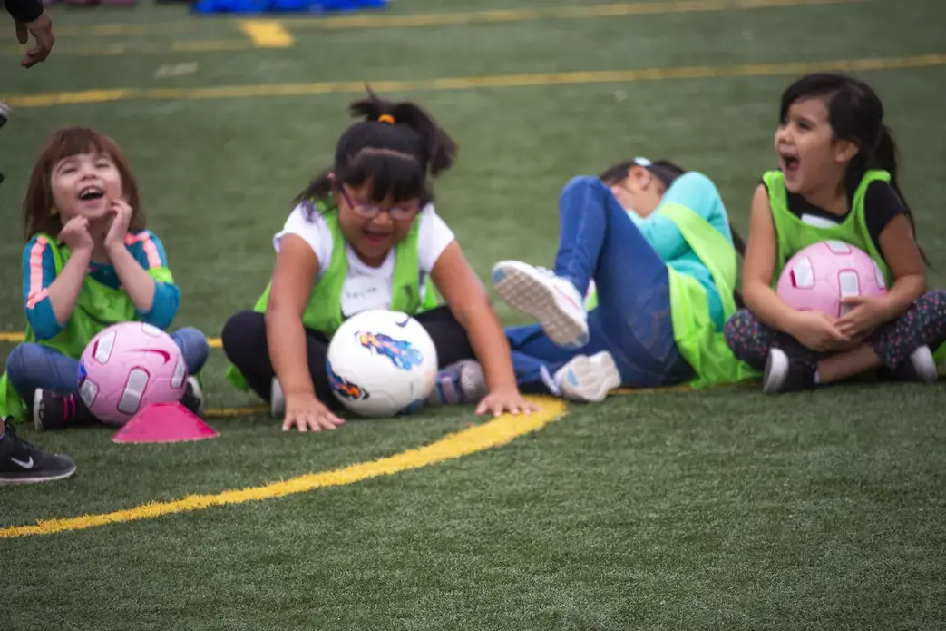 Los estudiantes se prepararon para un partido de práctica durante la clínica de fútbol en la Escuela Primaria Carroll en Bernalillo, Nuevo México. Se rieron mientras sus compañeros de clase eran contados en grupos por nombres de frutas como plátano, fresa y manzana. Imagen de Viridiana Vidales Coyt. Estados Unidos, 2017.