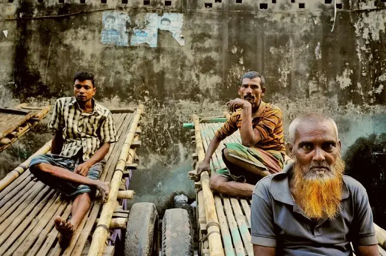 Tannery workers take a break before noon prayers. Their carts can carry a ton of goat skins through the narrow streets of Hazaribagh. Image by Larry C. Price. Bangladesh, 2016.