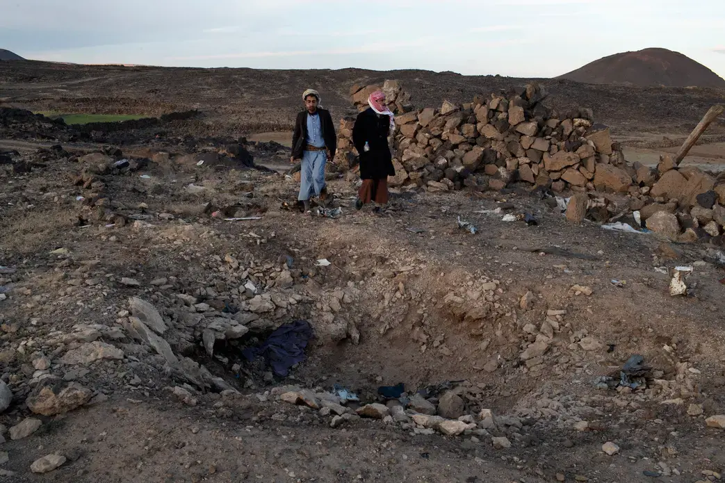 Jamal Muhammad Ali Qied (left), whose 14-year-old brother was killed in the airstrike, and Yahia al-Abdeli, who was injured and whose brother was killed, at the site of the attack. Image by Tyler Hicks/The New York Times. Yemen, 2018.