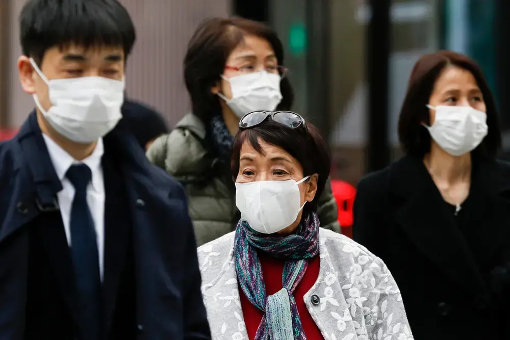 Pedestrians wearing surgical masks to prevent infectious diseases walk along the luxury area of Ginza. Japan has confirmed coronavirus infections cases in the country. Image by Shutterstock. Japan, 2020. Pedestrians wearing surgical masks to prevent infectious diseases walk along the luxury area of Ginza. Japan has confirmed coronavirus infections cases in the country. Image by Shutterstock. Japan, 2020.