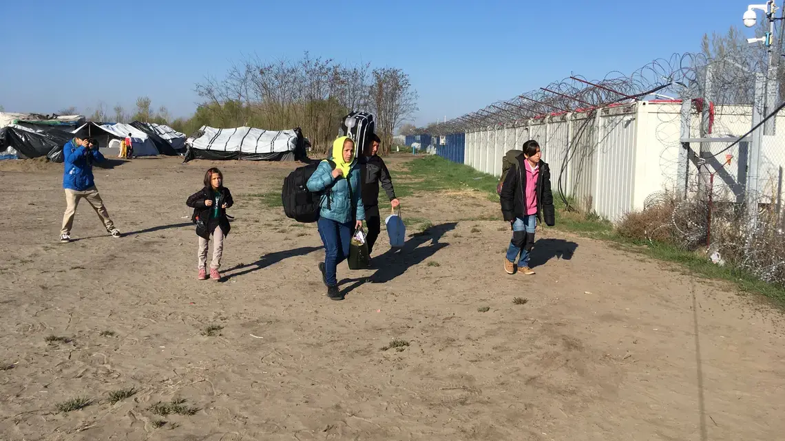 An Afghan family of four walks toward the Hungarian border to seek asylum. Under a controversial Hungarian policy that went into effect that day, they will be detained in a camp at the border while their case is decided. Image by Jeanne Carstensen. Hungary, 2017.