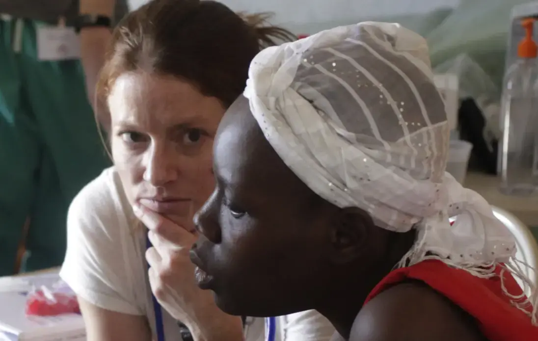 Dr. Ginny Ryan Buresh, a gynecologist from the University of Iowa, and a Haitian patient listen to an interpreter translate their discussion of health issues. Image by Mary Chind. Haiti, 2013. Media file: dmrdc5-69kvq14snvscj08oog1_original.jpg