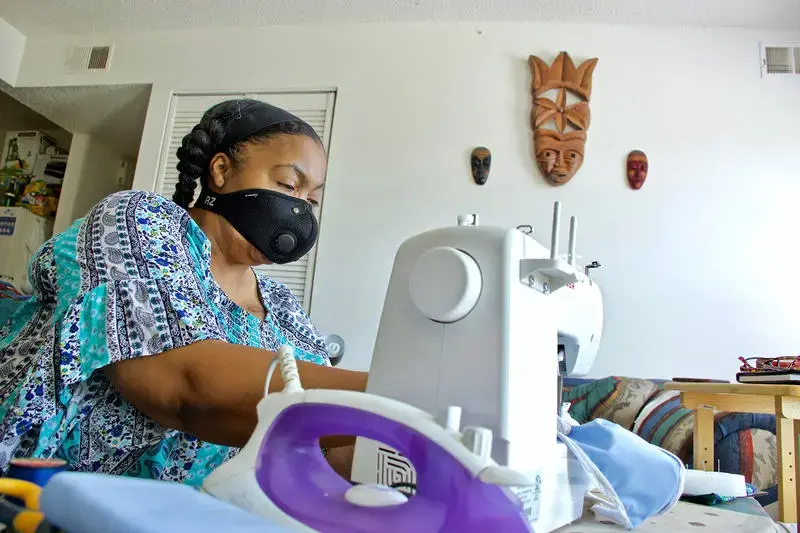 Kim Daniel makes her own masks for her protection at her home in Preservation Square. Image by Wiley Price / St. Louis American. United States, 2020. Kim Daniel makes her own masks for her protection at her home in Preservation Square. Image by Wiley Price / St. Louis American. United States, 2020.