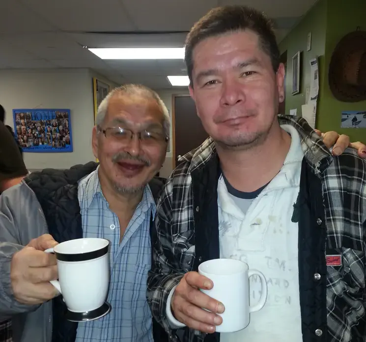 Simeonie Kunnuk (left) and Irwin Windsor drink the homemade wine. Image by Tina Rosenberg. Canada, 2016. Media file: simeonie_kunnuk_and_irwin_windsor.jpg