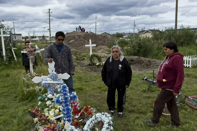Members of the Attawapiskat First Nation community gather in the St. Mary’s cemetery to visit the graves of loved ones. Despite the loss, there was a sense of connection and strength from the families, a testament to the resilience of the Cree people. Image by David Maurice Smith/Oculi. Canada, 2016.