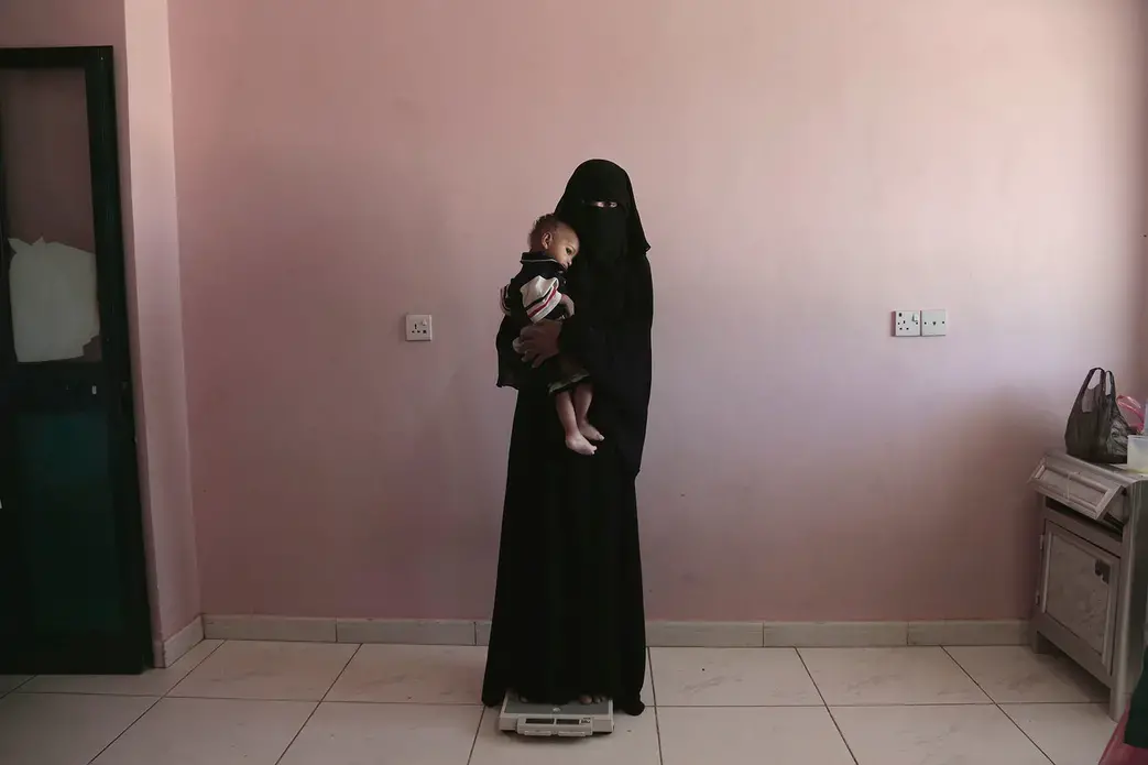 Umm Mizrah holds her baby Mizrah, in Aden, Yemen. Image by Nariman El-Mofty. Yemen, 2018. Umm Mizrah holds her baby Mizrah, in Aden, Yemen. Image by Nariman El-Mofty. Yemen, 2018.