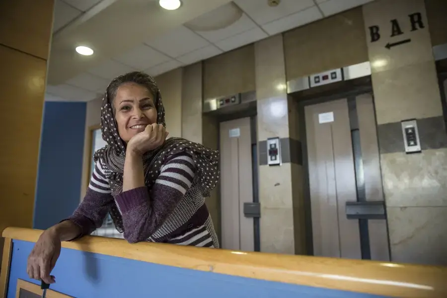 Jamila, an asylum-seeker from Iran and mother of four, is now staying with her children and grandchildren at the City Plaza Hotel in Athens, home to 300-plus immigrants, many of whom were staying in camps before the hotel was established as an alternative. Image by Jodi Hilton. Greece, 2016. Media file: jodihilton3.jpg