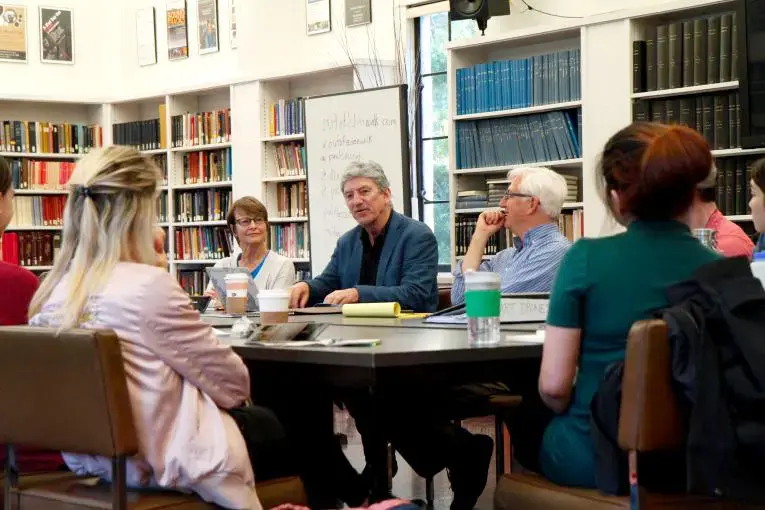 Don Belt (center), professor and university outreach director for the "Out of Eden" project, speaks to students and lecturers about international journalism at University of California, Berkeley. Image by Lauren Shepherd. United States, 2017.