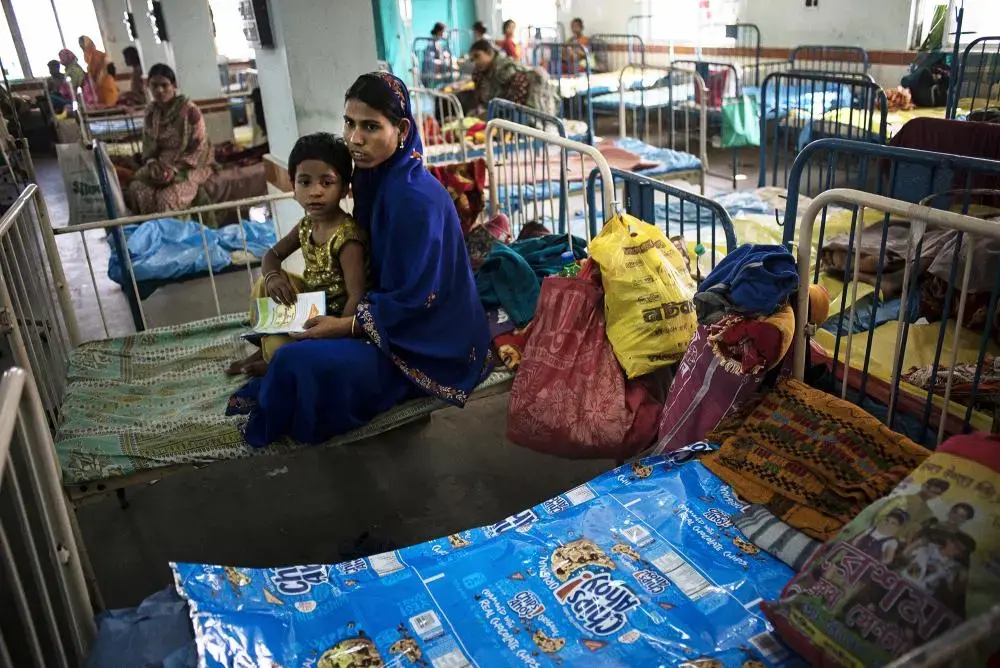 Families use package materials for Western food products, purchased from the small shops outside of the hospital, to cover the poorly maintained hospital beds at the Burdwan medical college hospital. Image by Sami Siva. India, 2014. Media file: hospitalcrisis-india-pulitzer-samisiva-09.jpg