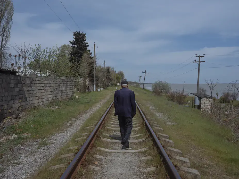 A man walks on railway tracks. Image by Emin Ozmen/Magnum Photos. Azerbaijan, 2018. A man walks on railway tracks. Image by Emin Ozmen/Magnum Photos. Azerbaijan, 2018.
