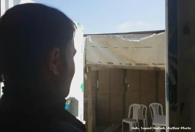 Norullah, who didn't want his face to be shown, looks on in a corner of the Independent Election Commission's compound. Image by Moh. Sayed Madadi. Afghanistan, 2014. Media file: cleaner_edit.jpg