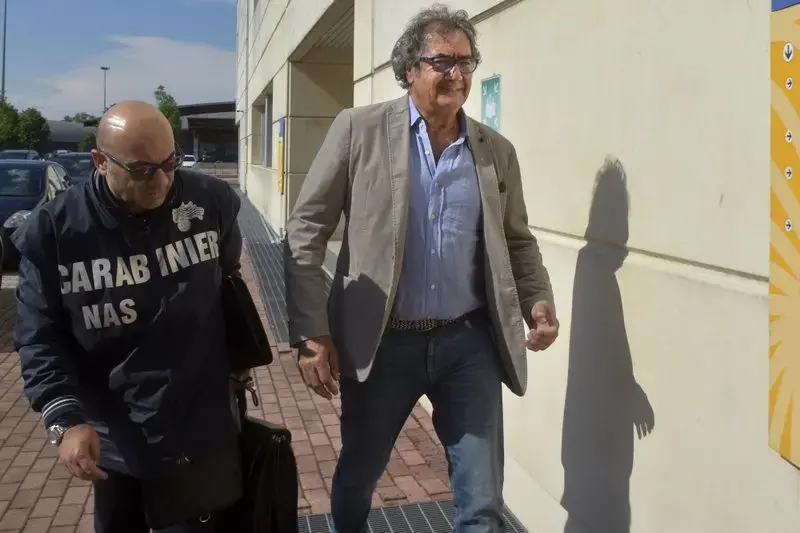 Dr. Guido Fanelli, right, is taken to the Carabinieri headquarters in Parma, Italy, for questioning in an alleged pharmaceutical kickback scheme on Monday, May 8, 2017. That morning, police jolted Fanelli out of bed. It was a spectacular fall from grace for a man who appeared days before on a popular television show to promote painkillers. Image by AP Photo/Marco Vasini. Italy, 2017. Dr. Guido Fanelli, right, is taken to the Carabinieri headquarters in Parma, Italy, for questioning in an alleged pharmaceutical kickback scheme on Monday, May 8, 2017. That morning, police jolted Fanelli out of bed. It was a spectacular fall from grace for a man who appeared days before on a popular television show to promote painkillers. Image by AP Photo/Marco Vasini. Italy, 2017.