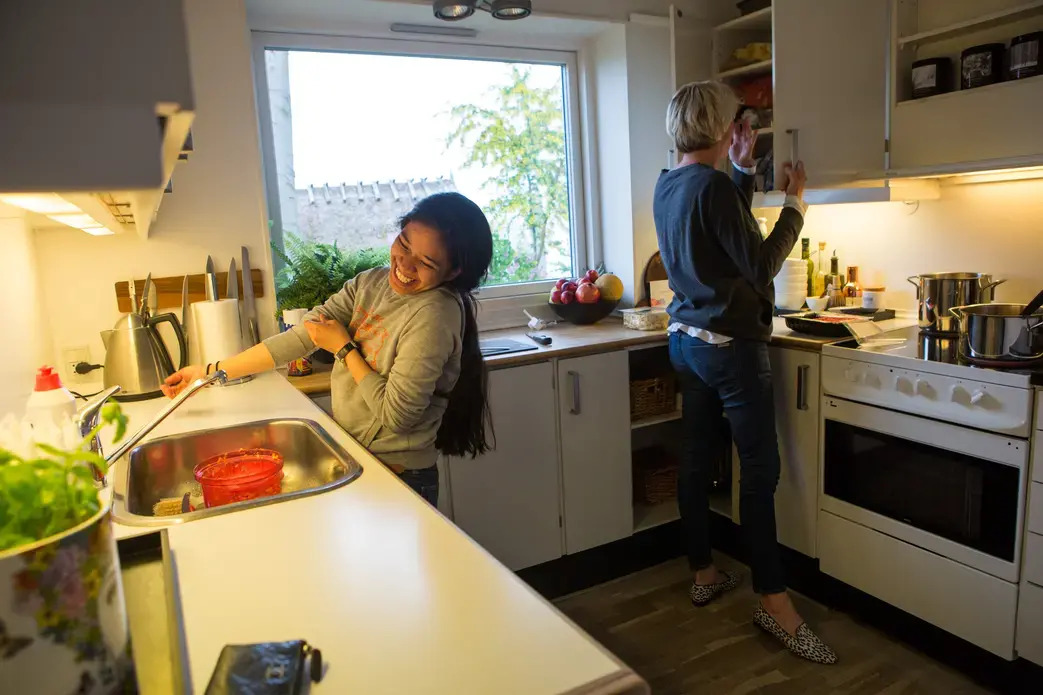 Jennifer D. Cuevas, left, helps Yvette Roepstorff, a fashion agent, make dinner at the Roepstorff home