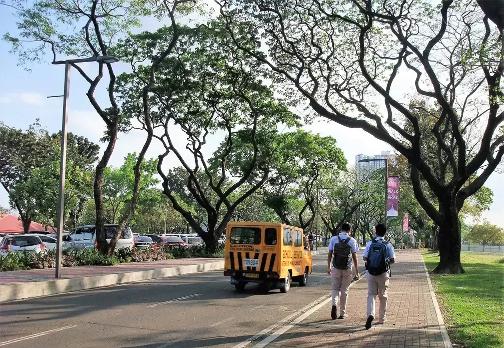 Ateneo’s solution: Build and maintain a network of wide sidewalks. Take care of old trees so that their canopy can shield the people who walk from the elements. Image by Dinna Louise C. Dayao. Philippines, 2017.