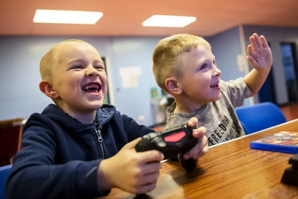 Kyle Hamilton, 7, left, and Lucas Barpon, 7, both of Possilpark, play a wrestling video game on a Playstation during a Young People's Futures session, Oct. 25, 2019, at Possilpoint Community Centre in Possilpark, Glasgow, Scotland. Image by Michael Santiago. United Kingdom, 2019.