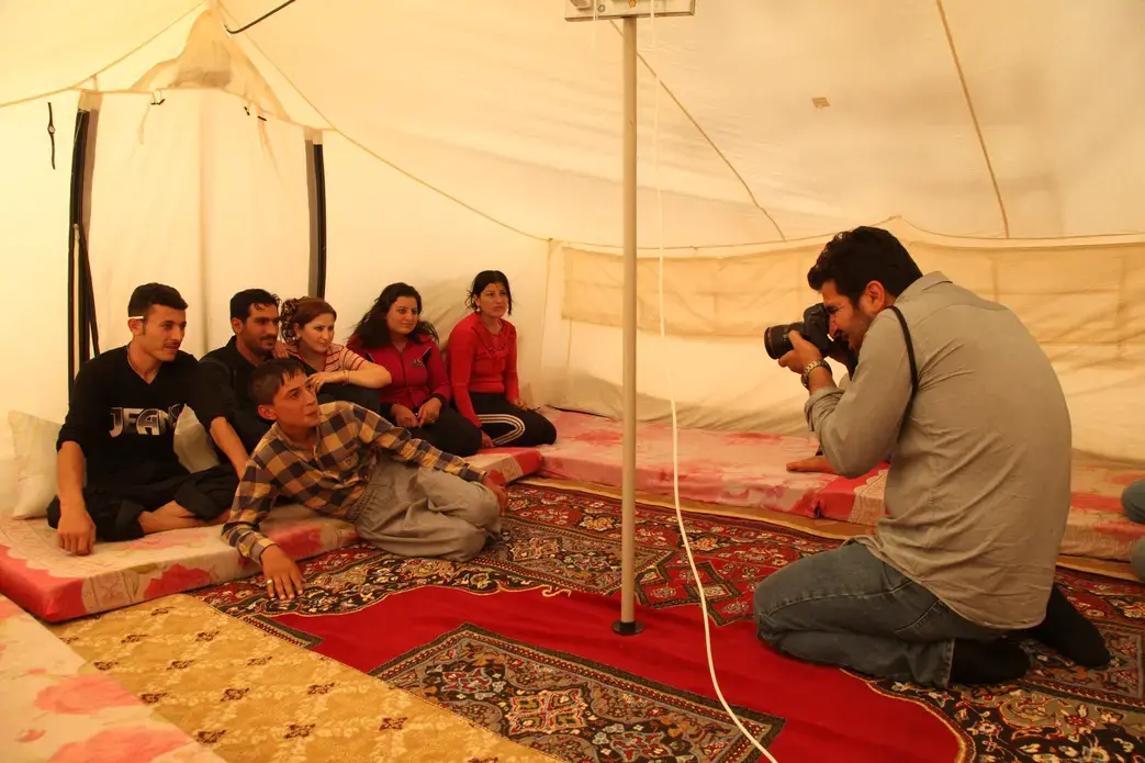Kamaran Najm takes a portrait of a family of Syrian refugees in Arbat, Iraq, on October 17, 2013. Image by Sebastian Meyer. Iraq, 2013. Media file: syrianfamilybts07.jpg