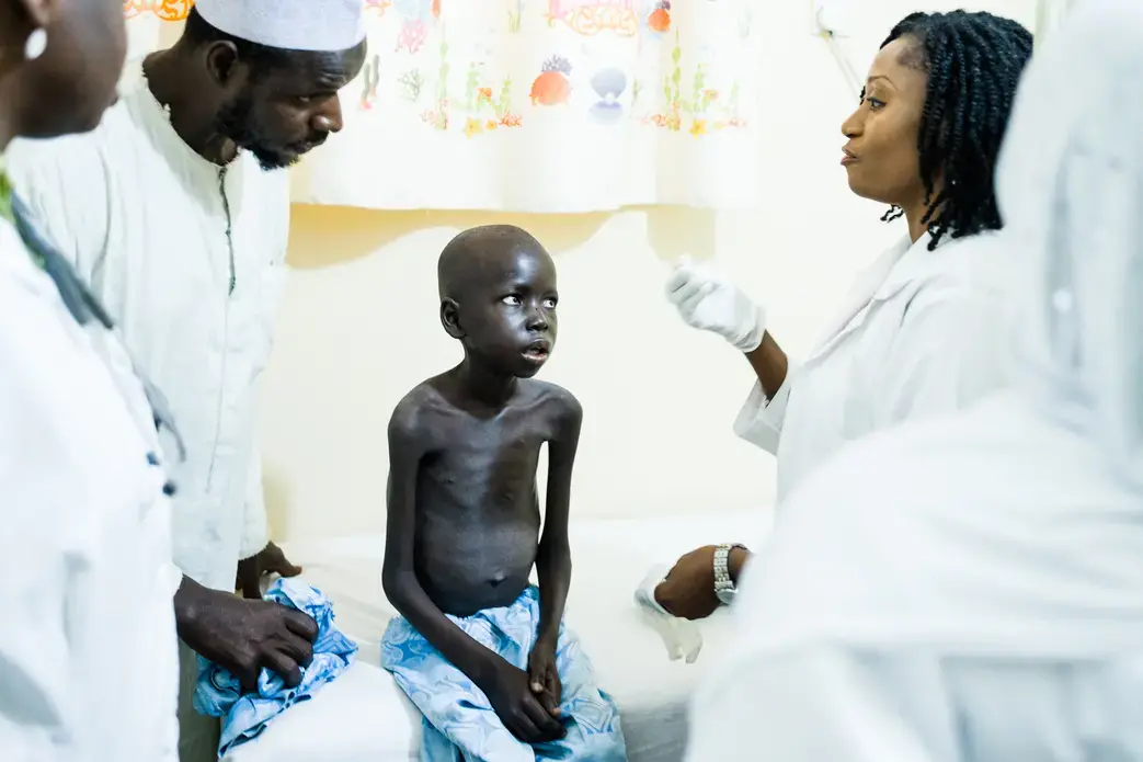 Yusuf Adamu, 12, in April arrived at Asokoro Hospital in Abuja, with a severe case of late-stage AIDS. Doctors suspected that he had tuberculosis and he’s shown here in the X-ray room. Adamu’s mother died from AIDS when he was 3, which is when he was first diagnosed. Yusuf’s father, Ibrahim, and his two other wives are infected, as is a sister. The impoverished family has difficulty paying the bus fares to travel from Yusuf’s home to the hospital for regular checkups and medication the necessary medication adjustments. Nigeria has more children infected by their mothers than any country in the world, and, in turn, the largest number of children dying from AIDS. Image by Misha Friedman. Nigeria, 2018. Media file: farfromover-1.jpg