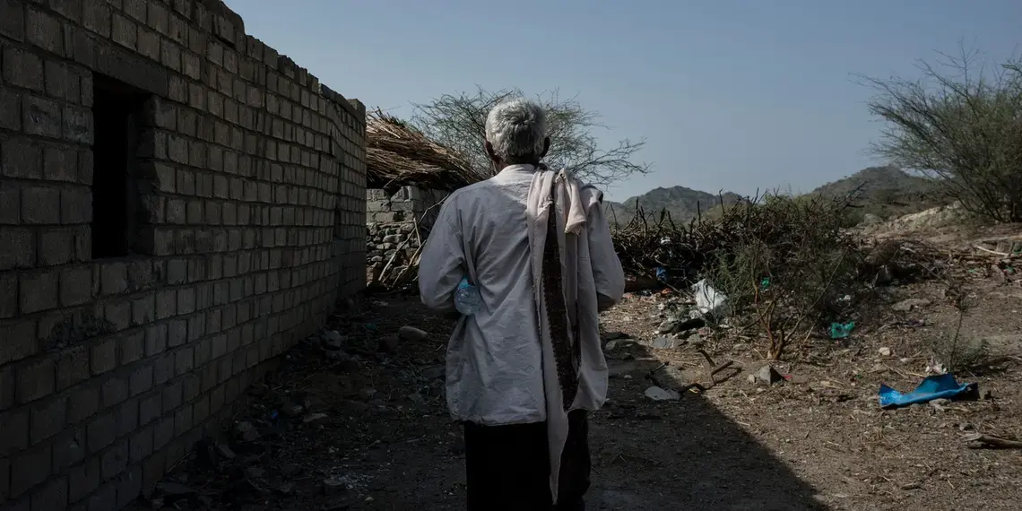 A Yemeni man walks through the rubble of a wedding tent. Image by Alex Potter. Yemen, 2018.