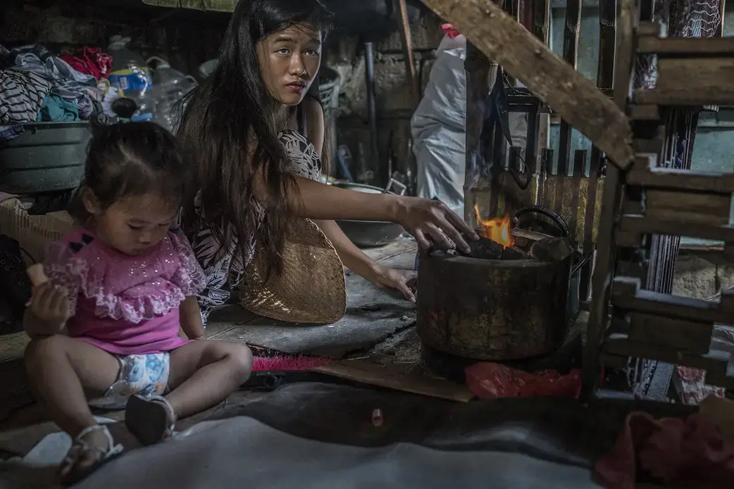 Jazmine Durana, a 16 year old widow and single mother, prepares a breakfast cooking fire, for Hazel's breakfast, in the one room slum dwelling in Navotas she shares with her parents, two brothers and a younger sister.  Hazel's biological father does not acknowledge the child is his and he now lives on the island of Samar, far from Metro Manila.  Jazmine met Toto while pregnant and he accepted her as his own.