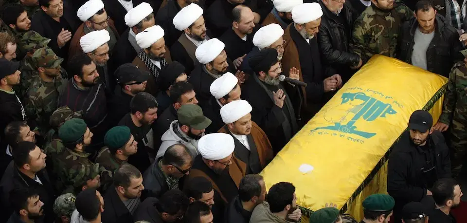 Mourners pray over the casket of Hezbollah leader Mohammed Issa in Lebanon after his death in an Israeli military operation in the Golan Heights. Image courtesy of Mahmoud Zayyat/AFP/Getty Images. Syria, 2015. Hezbollah Funeral