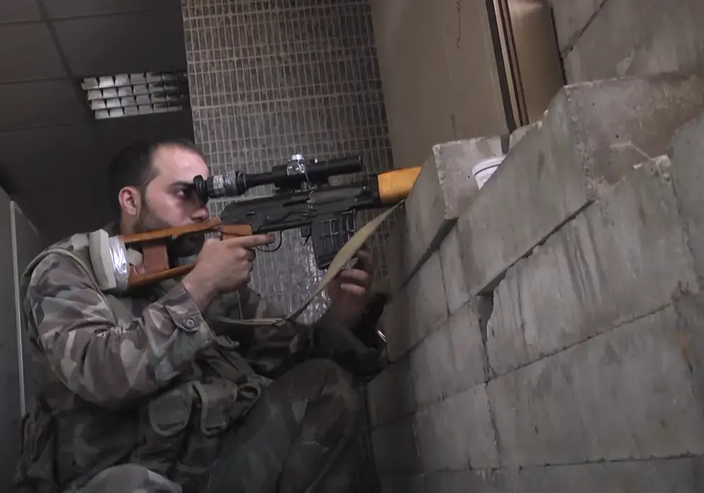 A Syrian soldier aims at rebel positions in southwestern Syria. Image courtesy of Abkhazian Network News Agency via Creative Commons. Syria, 2013. Syrian Army Sniper.