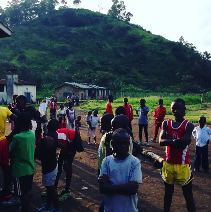 Runners gather early on Sunday morning for a community race at the makeshift soccer field in Kirotshe.