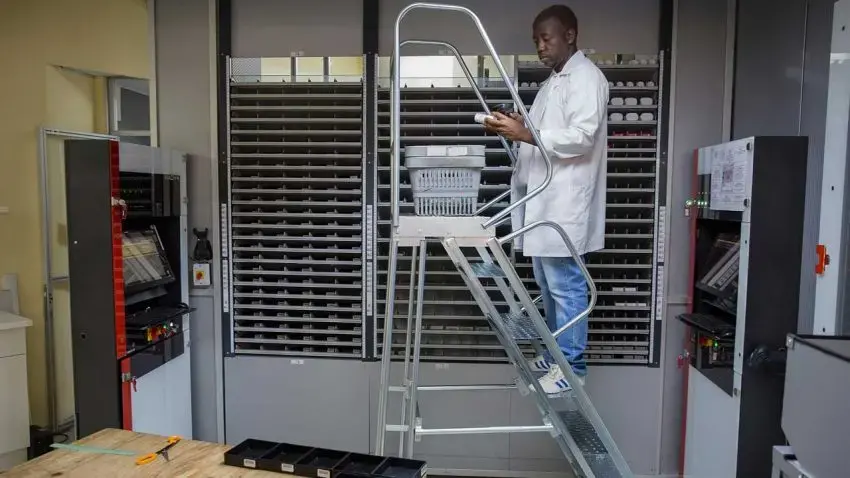 A staffer scans a bottle of pills that he then puts into the back of a Pharmacy Dispensing Unit — an ATM that may one day be in shopping malls. Image by James Oatway. South Africa, 2016. A staffer scans a bottle of pills that he then puts into the back of a Pharmacy Dispensing Unit — an ATM that may one day be in shopping malls.