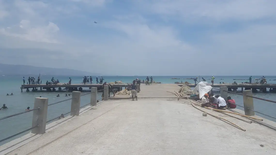 People work and play at a dock in Cite Soleil, near Port-au-Prince, Haiti. Few people in the community have access to safe sewage facilities. Image by Rebecca Hersher. Haiti, 2017.