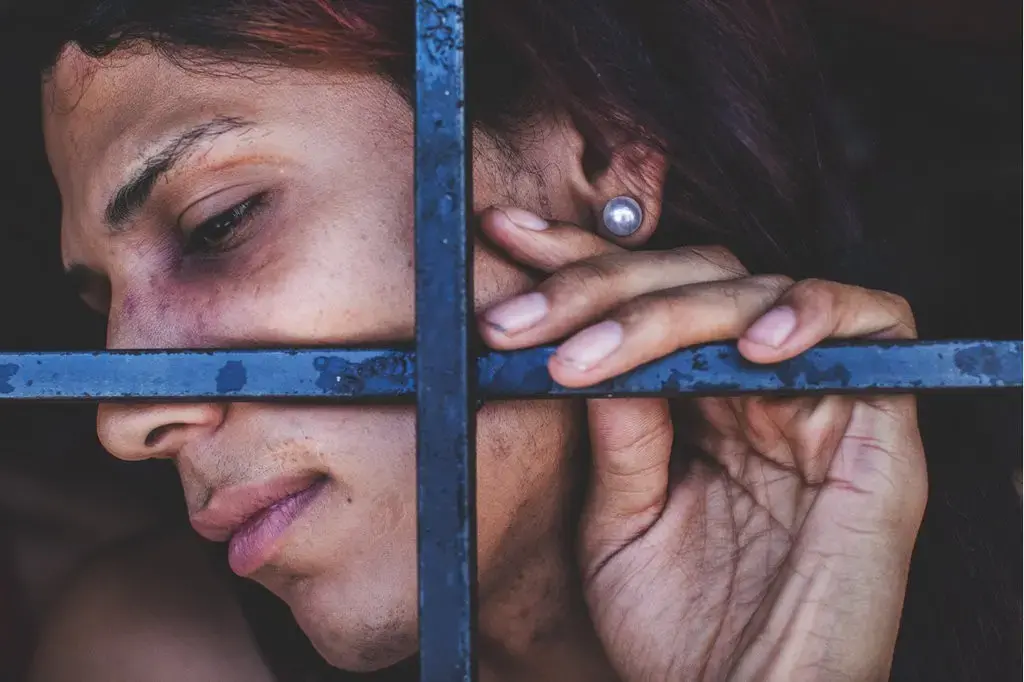 A bruised transgender woman is forced to wait for trial confined with male prisoners, many of whom abuse her. Image by Ana María Arévalo. Venezuela, 2017.