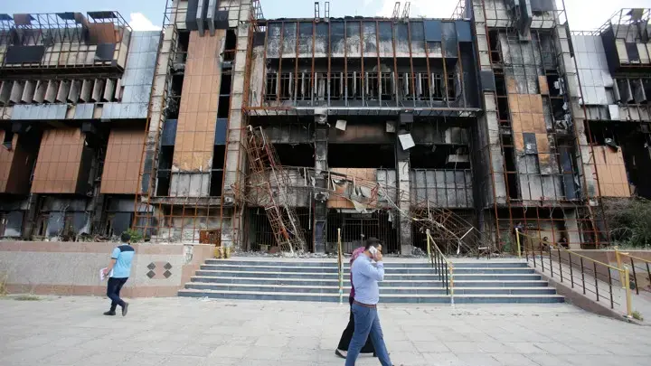 Iraqi students walk near a building of the central Library of the University of Mosul, May 14, 2018. Image by Khalid Al-Mousily for Reuters. Iraq, 2018.