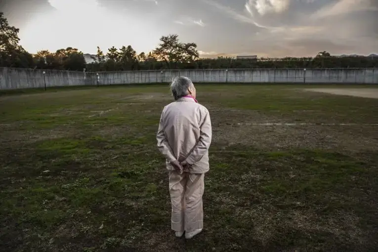 Ms. K, 89, stands in prison yard. Image by Shiho Fukada. Japan, 2018.