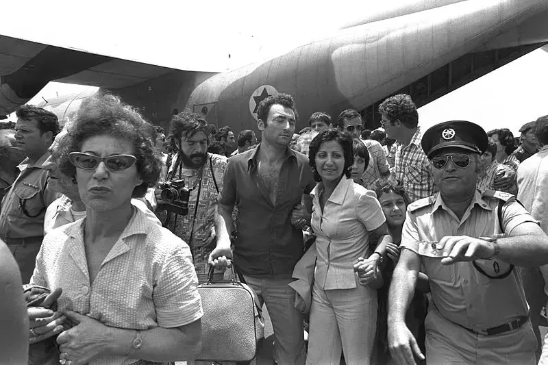 A policeman clears the way for rescued Air France hostages returning from Entebbe Airport, on July 4, 1976. Image courtesy of Moshe Milner/GPO. Israel, 1976. Entebbe Airport hostage return