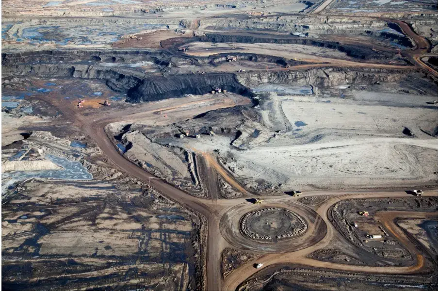 Tar sands mines dwarf the mammoth trucks—with house-size buckets—that operate there. Image by Alex MacLean. Canada, 2014. Media file: mine_photo.jpg
