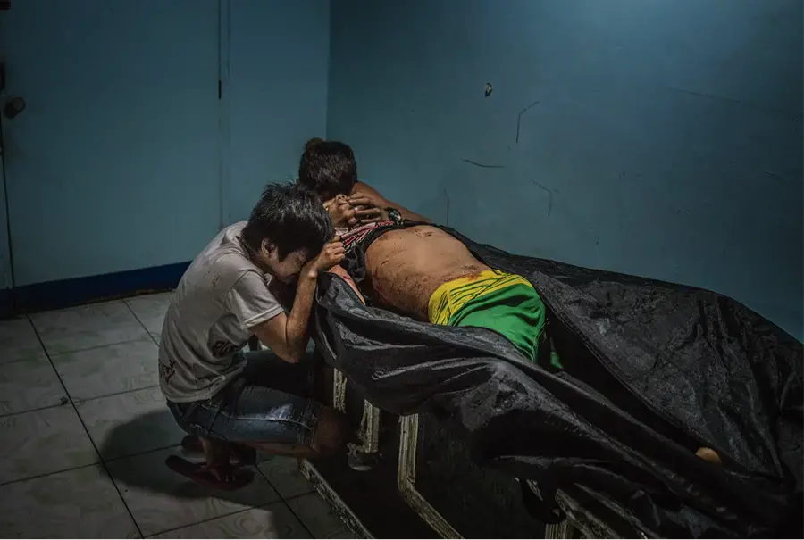 Ginnalyn Soriano and her youngest brother, Jonas, at the morgue with their eldest brother, Julius. Image by James Whitlow Delano. Philippines, 2017. Ginnalyn Soriano and her youngest brother, Jonas, at the morgue with their eldest brother, Julius. Image by James Whitlow Delano. Philippines, 2017.