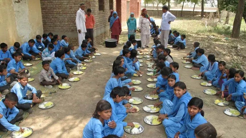 Schoolchildren in Haryana, India, eat rice and kadhi, a curry made with onions, garlic, yogurt and fritters made with chick pea flour. Image by Rhitu Chatterjee. India, 2014. Media file: mdm_show7.jpg