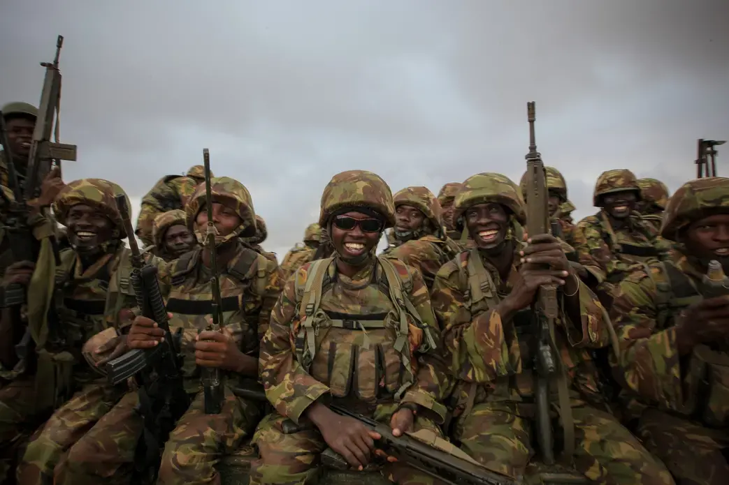 Troops from the Kenyan Contingent of the African Union Mission in Somalia (AMISOM) sit on the back of a flat-bed military truck as they begin an advance on the Somali port city of Kismayo. On Oct. 2, 2012, Kenyan AMISOM troops moved into and through Kismayo, the last major urban stronghold of the Al-Qaeda-affiliated extremist group Al Shabaab, on their way to the city's airport without a shot being fired following a month-long operation to liberate towns and villages across southern Somalia. Image courtesy of Creative Commons/AU-UN IST PHOTO/ STUART PRICE. Somalia, 2012. Media file: 8049963785_e8483634d1_o.jpg