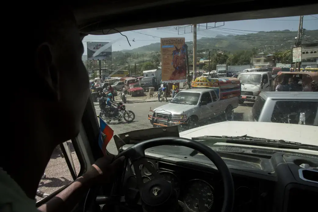 Traffic in downtown Port-au-Prince, Haiti. Elide Jean Petrus, 46, drives a truck through traffic in downtown Port-au-Prince, Haiti. Image by Marie Arago. Haiti, 2017.