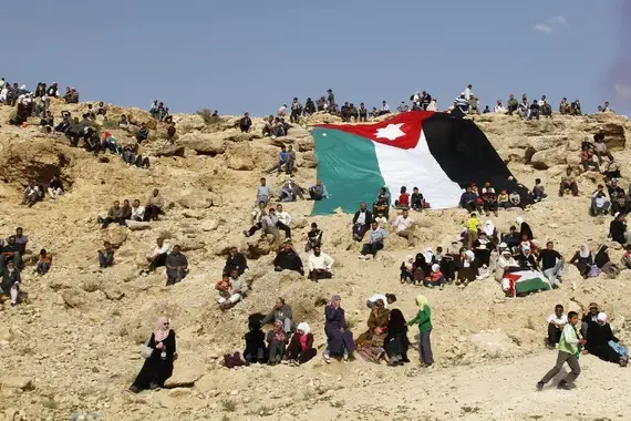 A group of Palestinian refugees gathered around a large Jordanian flag. Image by Muhammad Hamed/Reuters. Jordan, 2014. Media file: atlantic_jo.jpg