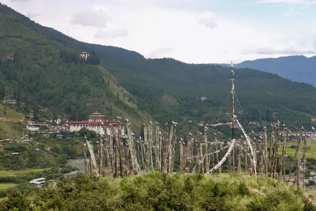 A view of prayer flags and the Paro dzong, or fortress, in Paro, Bhutan. Image by Emma Johnson. Bhutan, 2019.