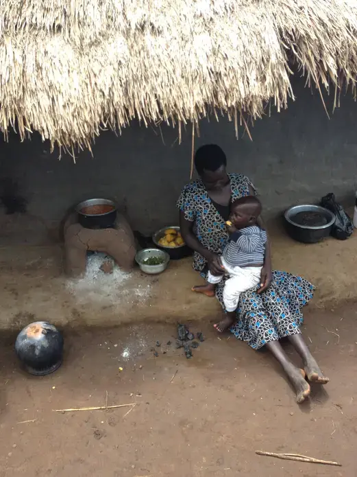Lunchtime in northern Uganda. A mother and her child enjoy sweet potatoes rich in Vitamin A and beans with higher iron content. Image by Roger Thurow. Uganda, 2014. Media file: img_0071.jpg