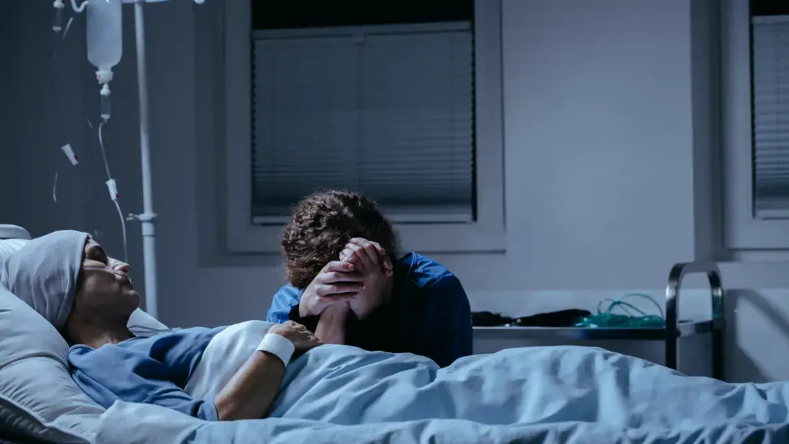 Daughter crying at her dying mother's bed in the hospital. Image by Shutterstock.