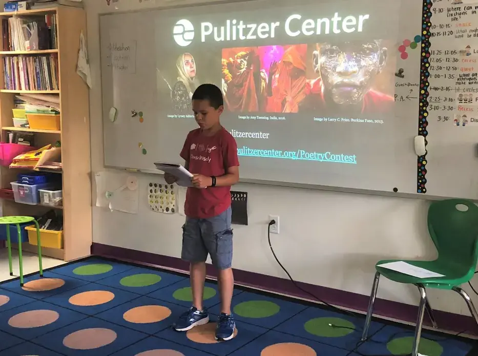 A 3rd grade student at Washington Yu Ying Public Charter School in D.C. performs their Fighting Words poem for the class. Image by Hannah Berk. United States, 2019. A 3rd grade student at Washington Yu Ying Public Charter School in D.C. performs their Fighting Words poem for the class. Image by Hannah Berk. United States, 2019.