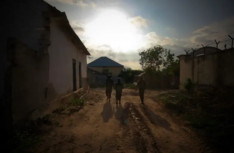 Ugandan soldiers serving with the African Union Mission in Somalia (AMISOM) 33rd Battalion walk between defensive positions along the frontline in Yaaqshiid District of Mogadishu, where AMISOM forces have pushed Al Shabaab militants beyond the city's northern fringes to the outskirts of the Somali capital. AU/UN Image by Stuart Price. Somalia, 2011. (CC0 1.0).